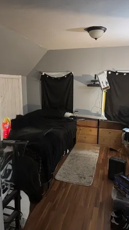a bedroom with a bed and wooden floor