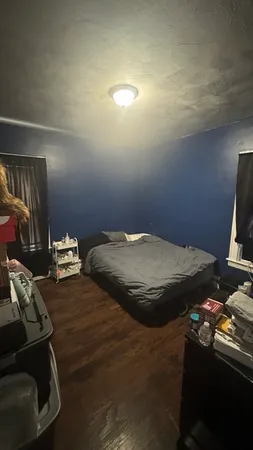 a bedroom with a bed and a flat tv screen on the dresser