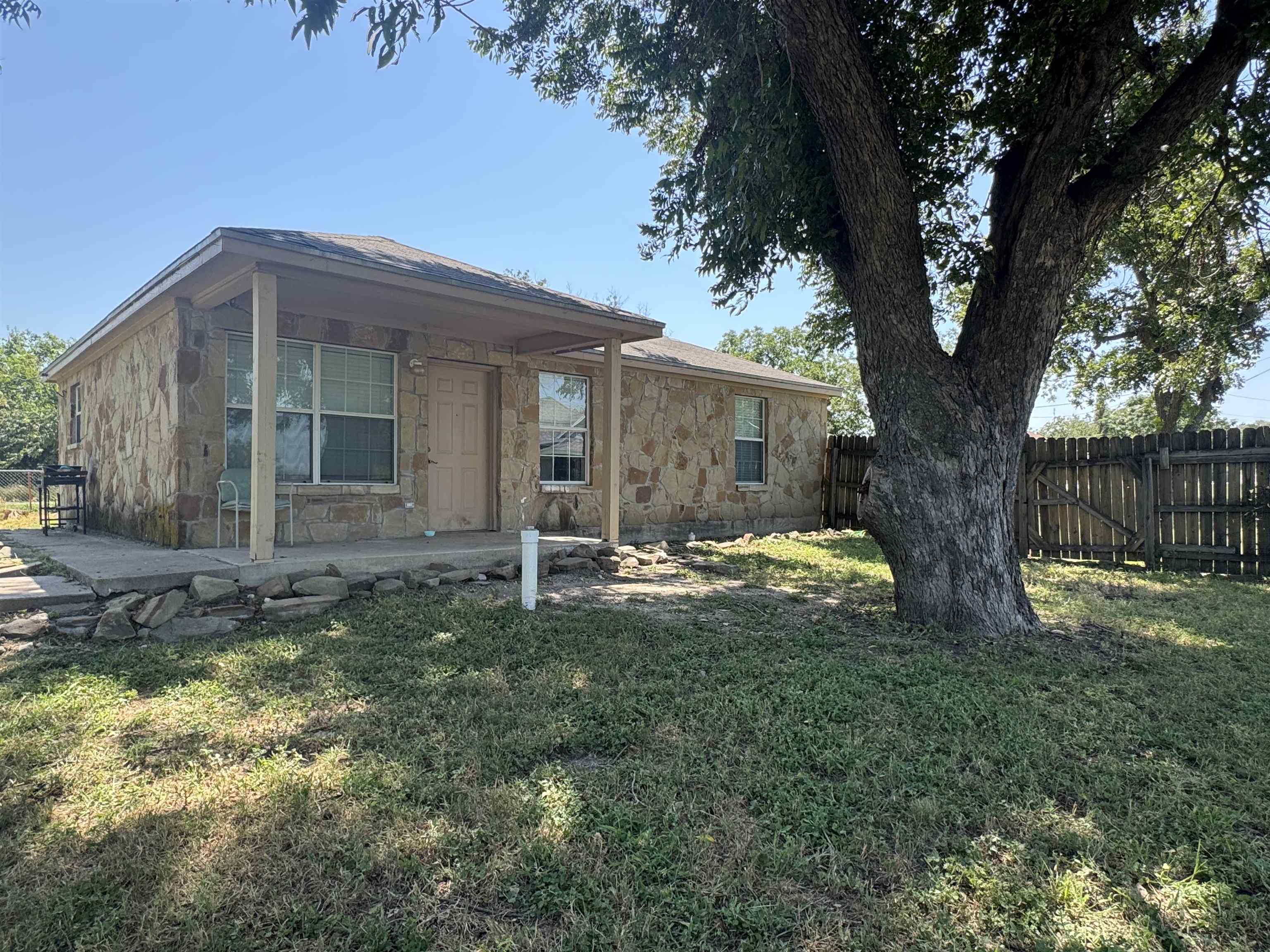 a view of a house with backyard and a tree