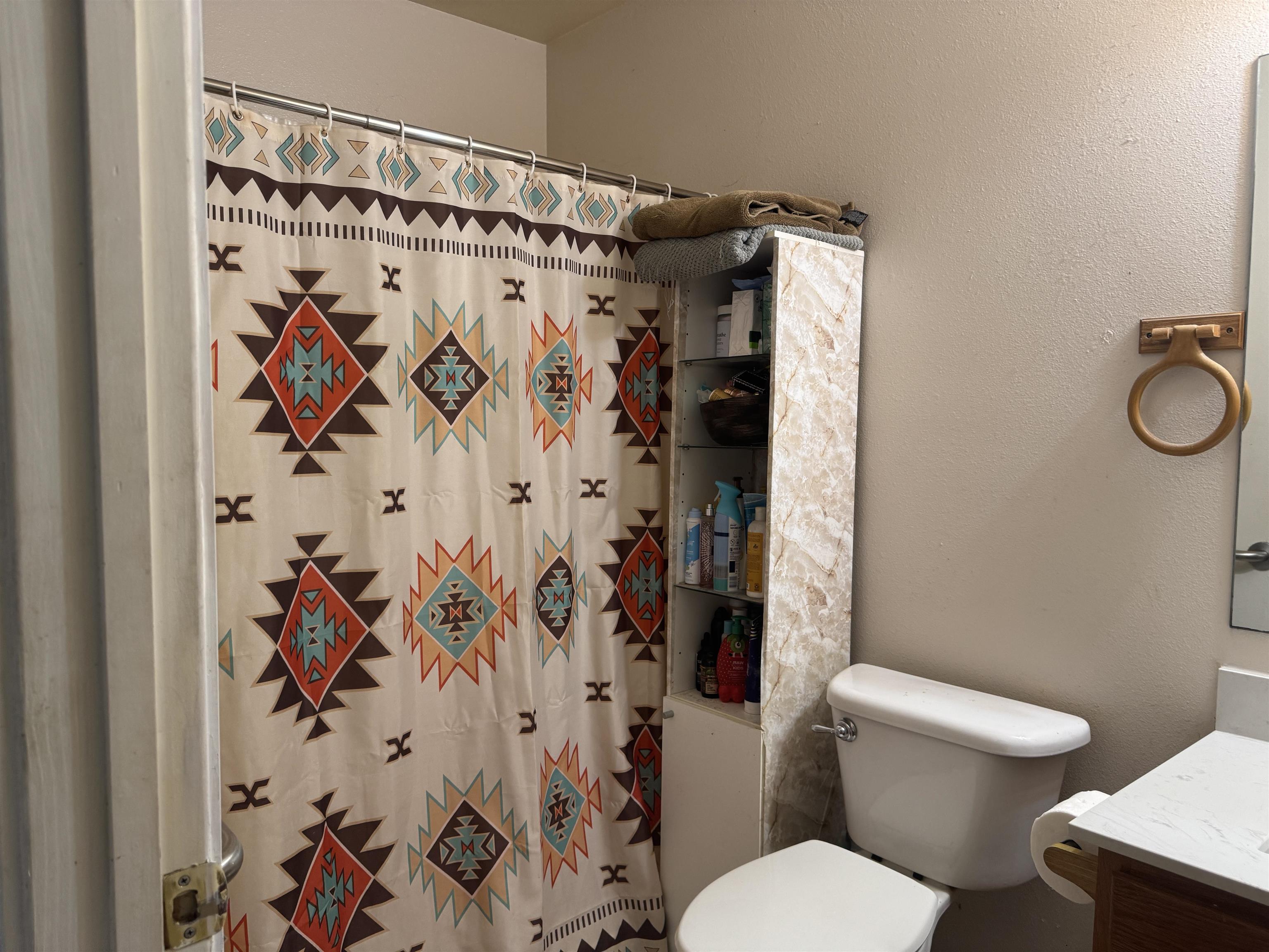 200 North 7th Street Lometa, TX 76853 - Photo 11 of 16 a white toilet sitting next to a shower curtain