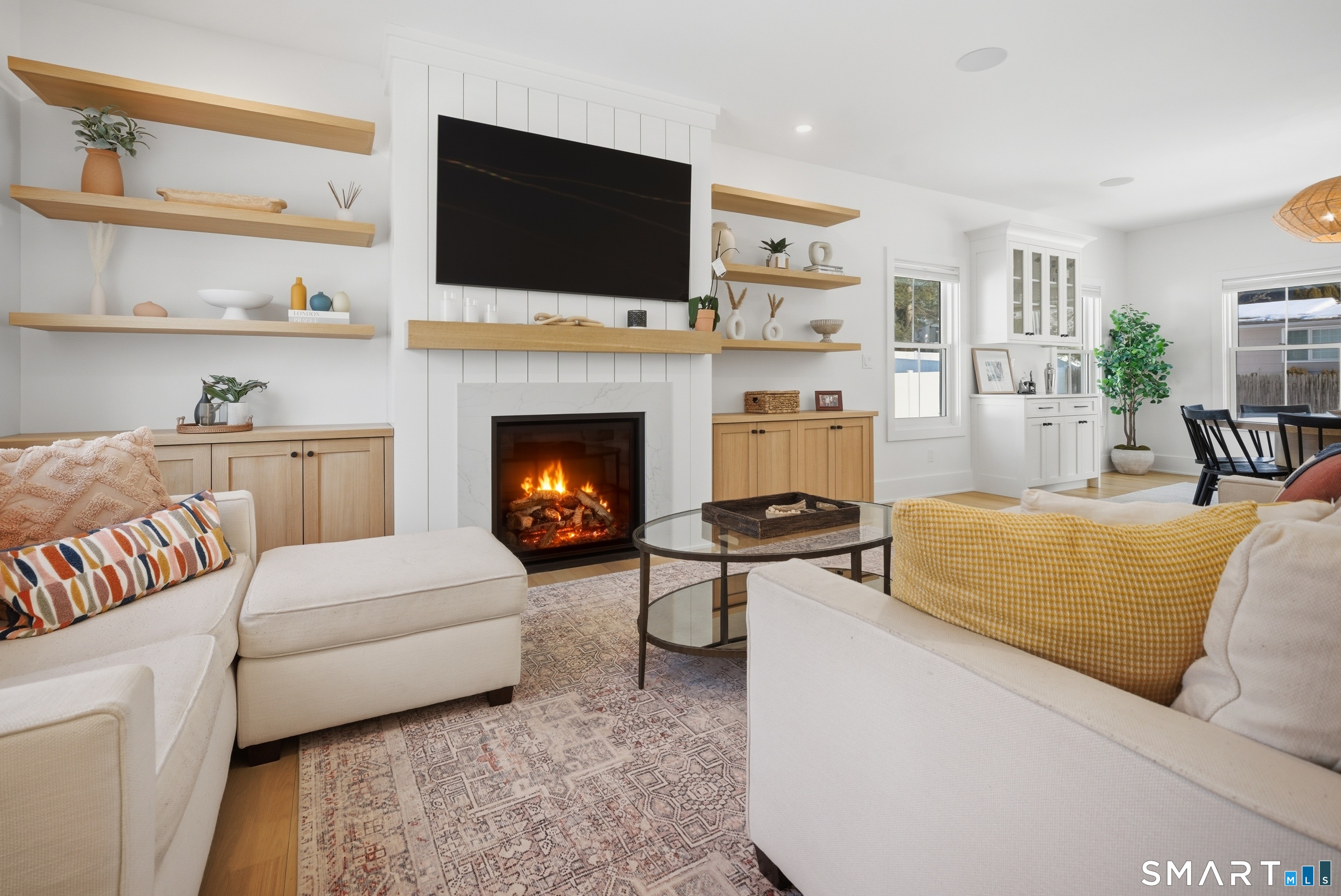196 Robin Lane Fairfield, CT 06824 - Photo 15 of 37 a living room with furniture a flat screen tv and a fireplace