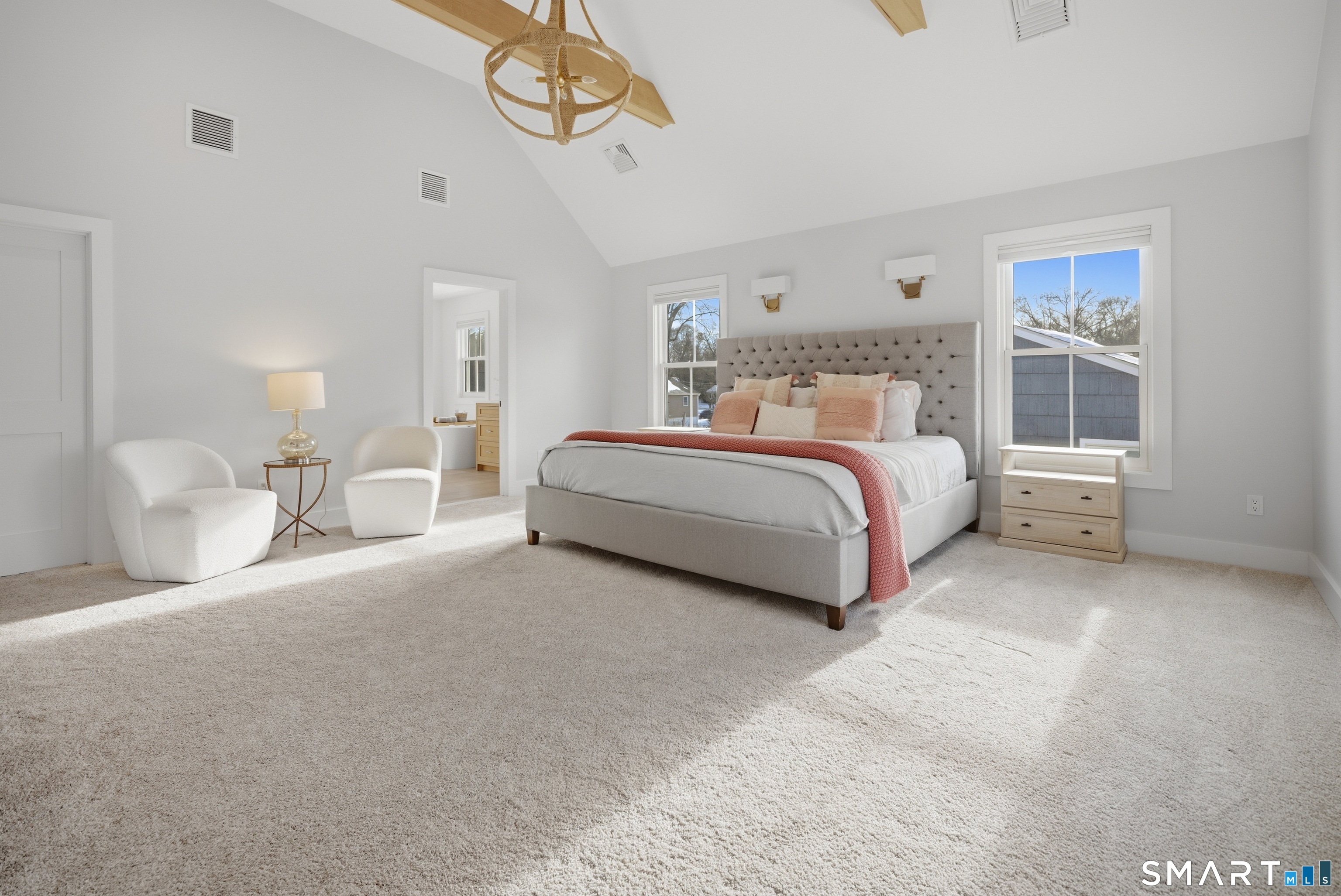 196 Robin Lane Fairfield, CT 06824 - Photo 27 of 37 a spacious bedroom with a bed a chandelier and windows