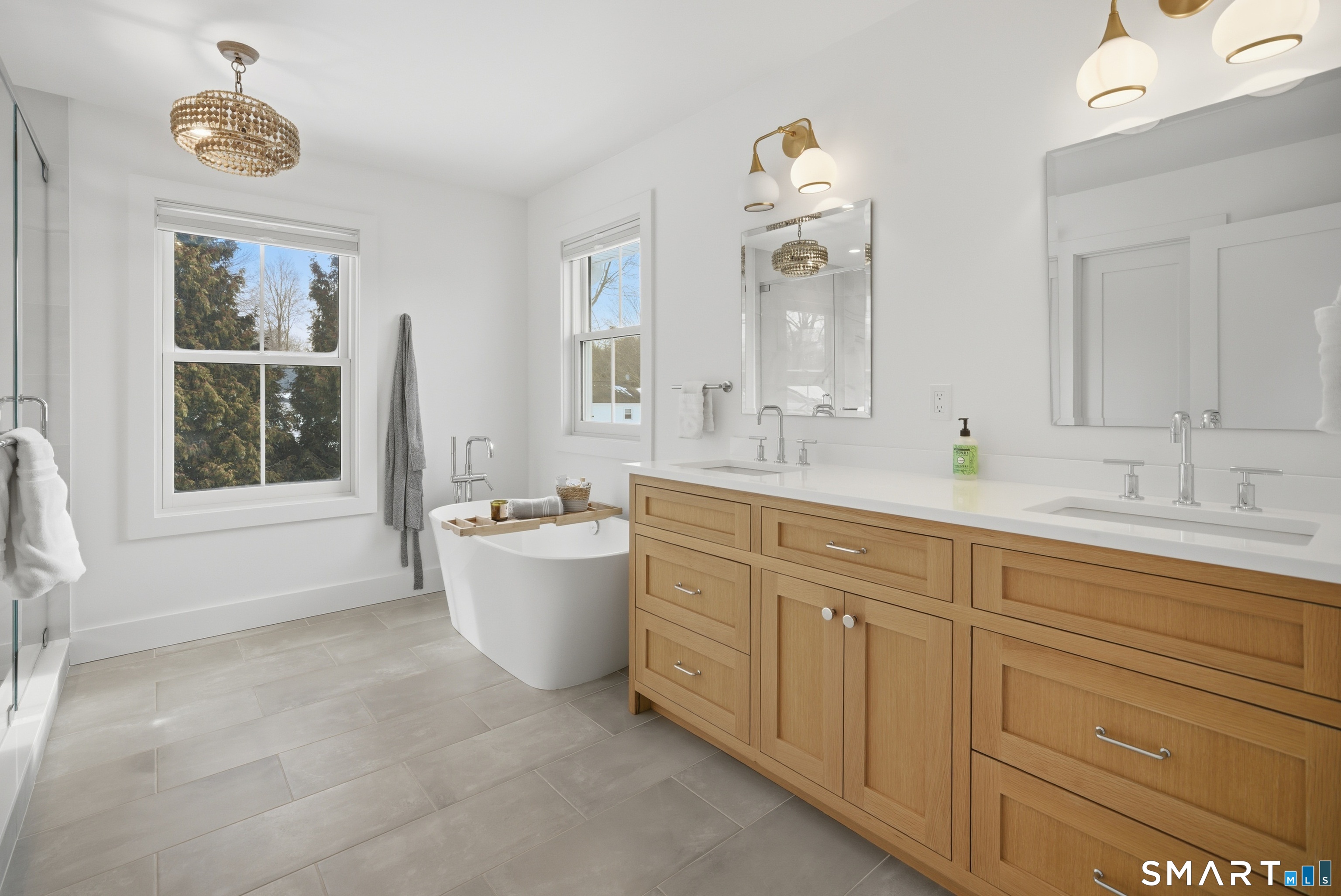 196 Robin Lane Fairfield, CT 06824 - Photo 29 of 37 a spacious bathroom with a double vanity sink a large mirror a bathtub and window
