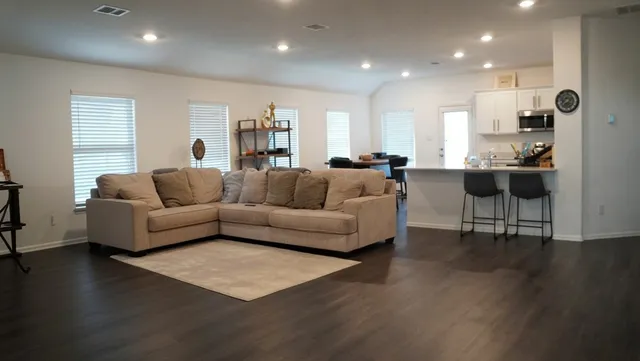 a living room with furniture wooden floor and a large window