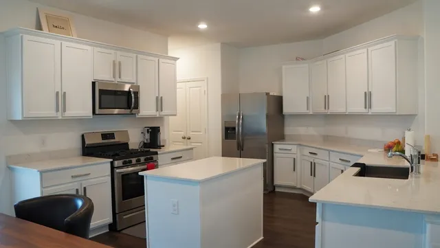 a kitchen with stainless steel appliances a stove microwave sink refrigerator and cabinets