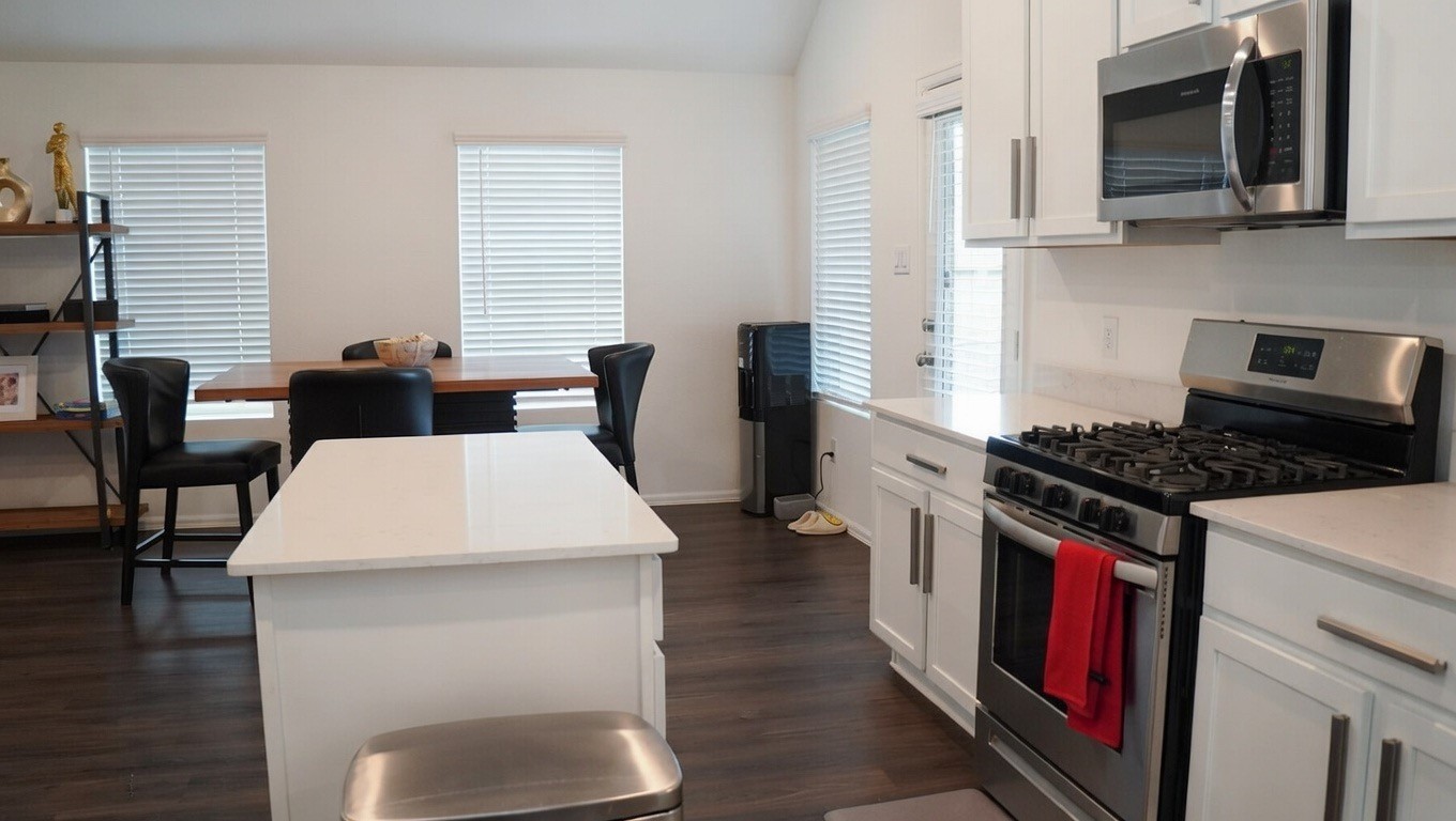 5307 Rushing Brk Lane Rosenberg, TX 77469 - Photo 7 of 8 a kitchen with stainless steel appliances granite countertop a stove top oven a sink a dining table and chairs