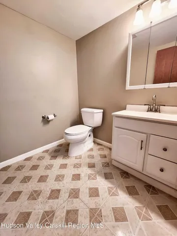 a bathroom with a sink a toilet and a mirror