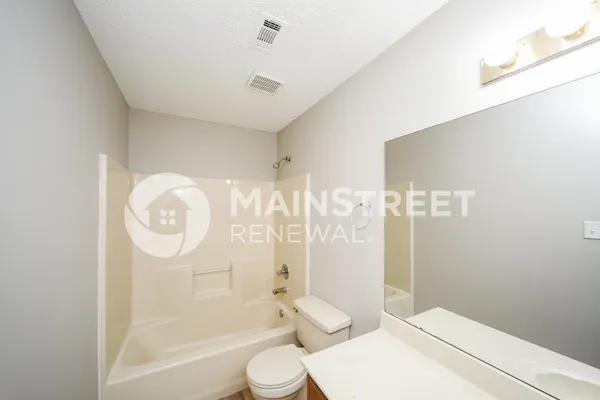 a bathroom with a toilet sink and shower