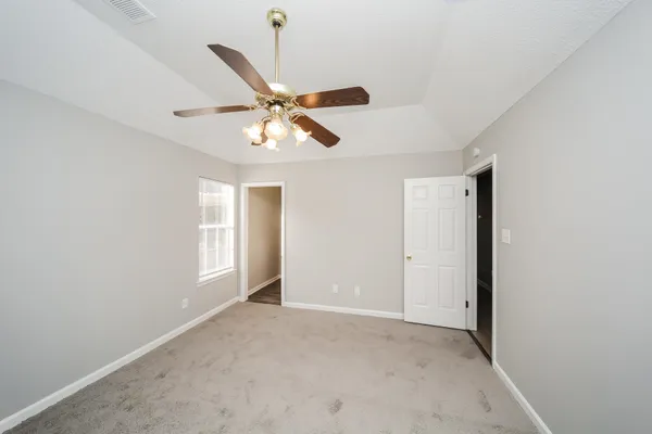 an empty room with a window and a fan