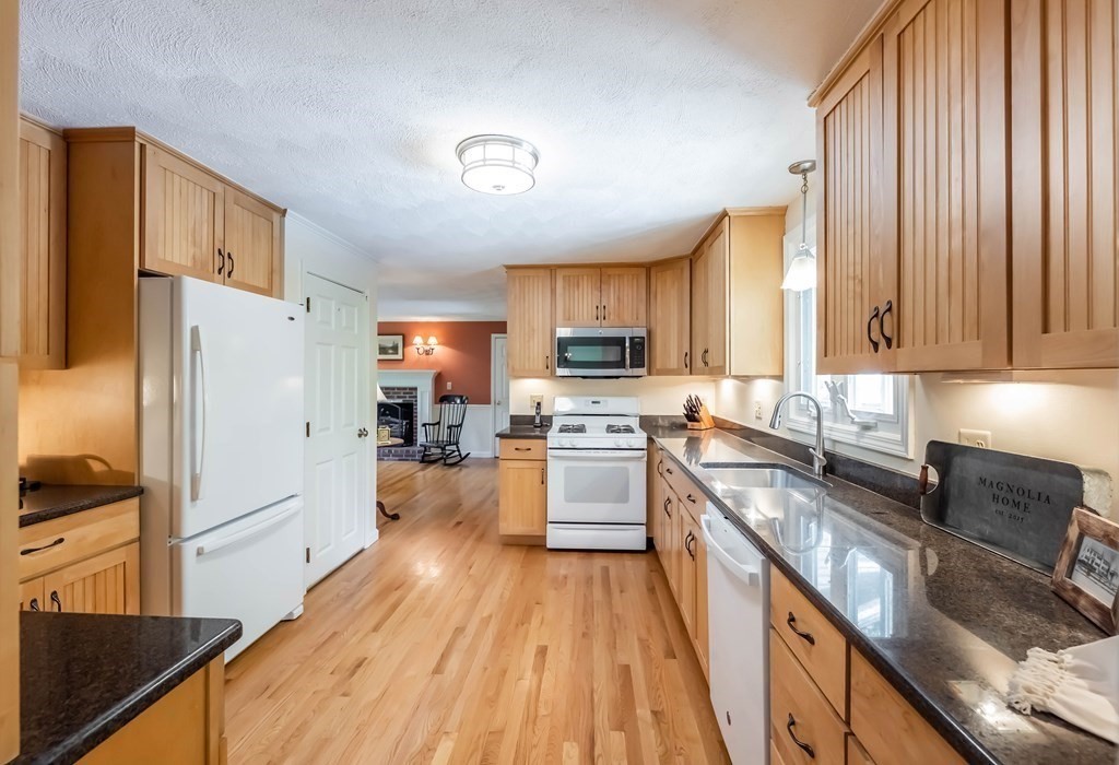 10 Peach Tree Path Andover, MA 01810 - Photo 11 of 42 a kitchen with granite countertop wooden floors stainless steel appliances a sink and a window