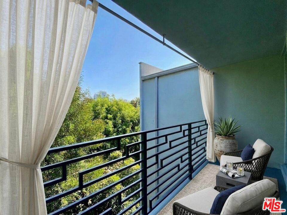 1920 Hillcrest Road, Unit 12 Los Angeles, CA 90068 - Photo 1 of 25 a balcony view with a potted plant on a table