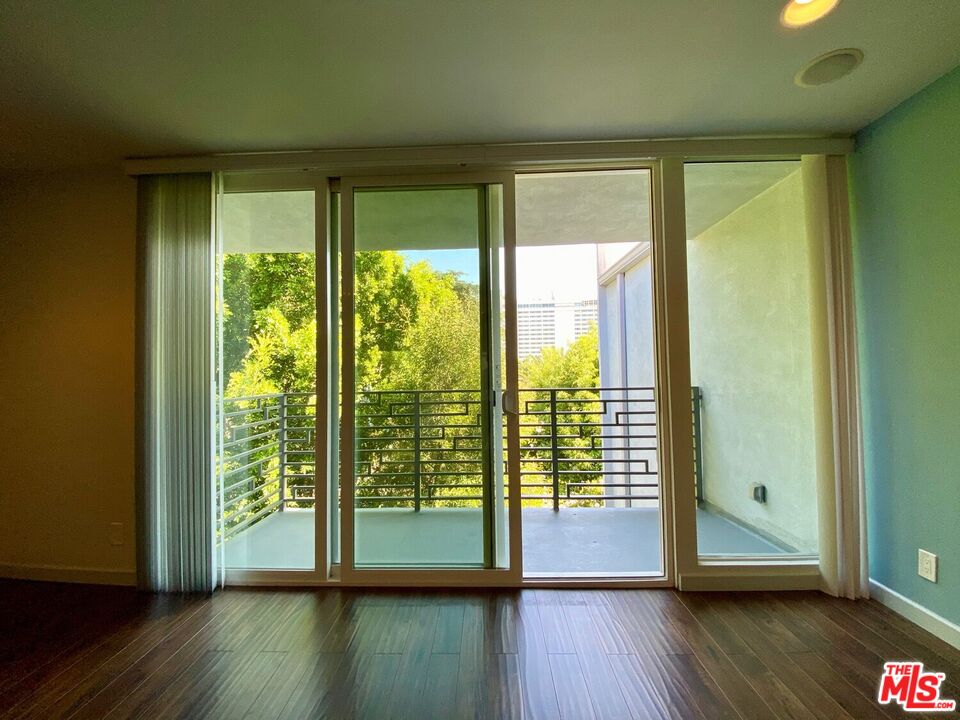 1920 Hillcrest Road, Unit 12 Los Angeles, CA 90068 - Photo 11 of 25 a view of an empty room with wooden floor and a window