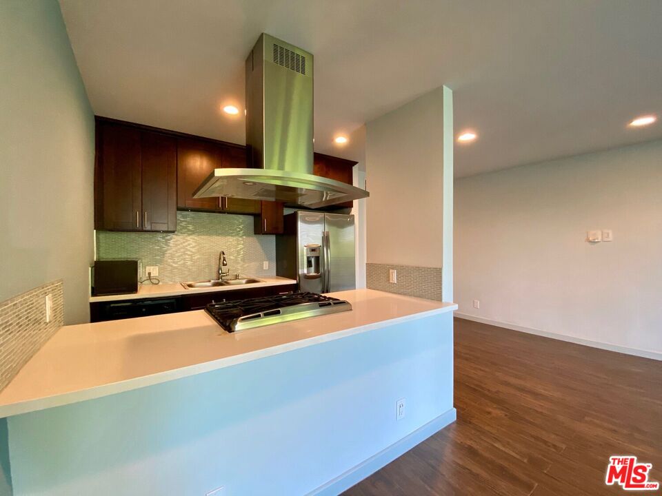 1920 Hillcrest Road, Unit 12 Los Angeles, CA 90068 - Photo 15 of 25 a room with wooden floor table and gym equipment