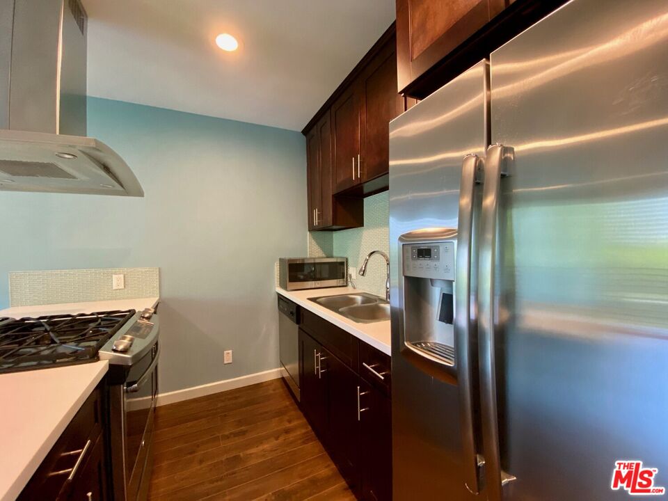 1920 Hillcrest Road, Unit 12 Los Angeles, CA 90068 - Photo 16 of 25 a kitchen with stainless steel appliances granite countertop a sink a stove and a refrigerator