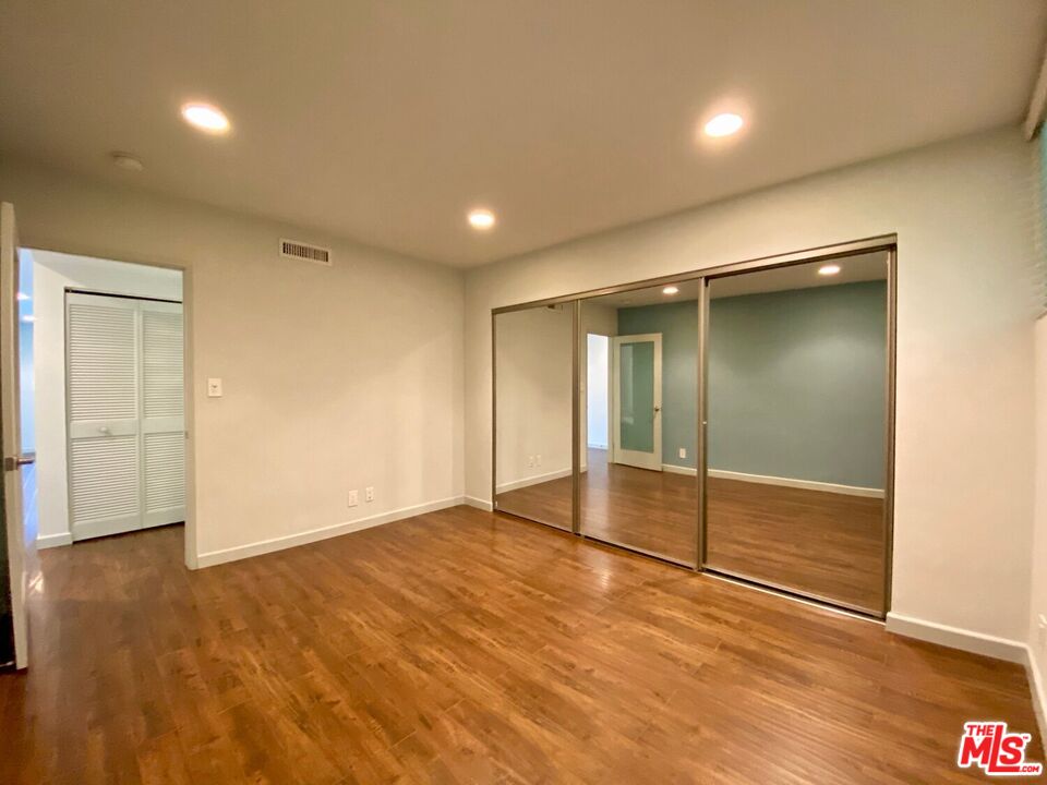 1920 Hillcrest Road, Unit 12 Los Angeles, CA 90068 - Photo 20 of 25 an empty room with wooden floor and door
