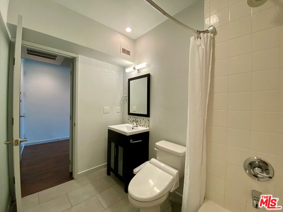 1920 Hillcrest Road, Unit 12 Los Angeles, CA 90068 - Photo 22 of 25 a bathroom with a toilet a sink and mirror