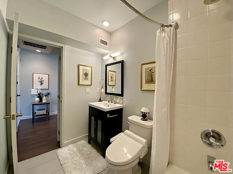 1920 Hillcrest Road, Unit 12 Los Angeles, CA 90068 - Photo 7 of 25 a bathroom with a toilet a sink and mirror