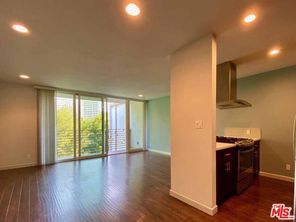 1920 Hillcrest Road, Unit 12 Los Angeles, CA 90068 - Photo 10 of 25 a view of an empty room with wooden floor and a window