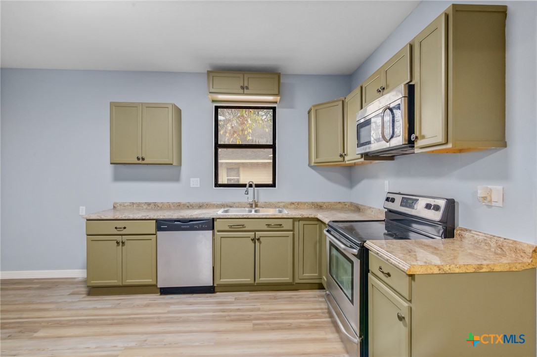 406 Hubbard Street Yoakum, TX 77995 - Photo 11 of 37 a kitchen with stainless steel appliances granite countertop a sink and cabinets