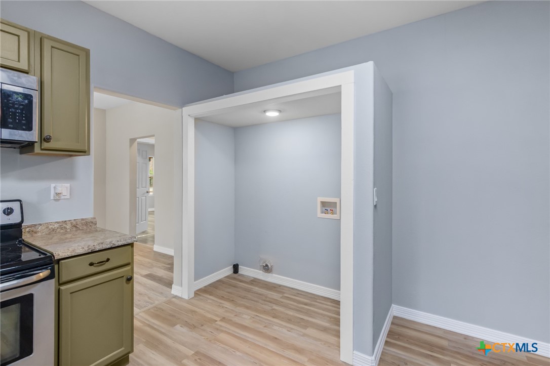 406 Hubbard Street Yoakum, TX 77995 - Photo 14 of 37 a view of kitchen with granite countertop cabinets appliances and a wooden floor