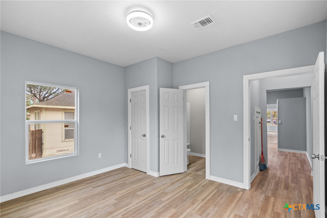 406 Hubbard Street Yoakum, TX 77995 - Photo 24 of 37 an empty room with wooden floor and windows