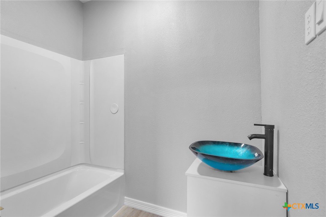 406 Hubbard Street Yoakum, TX 77995 - Photo 25 of 37 a bathroom with a sink and a tub