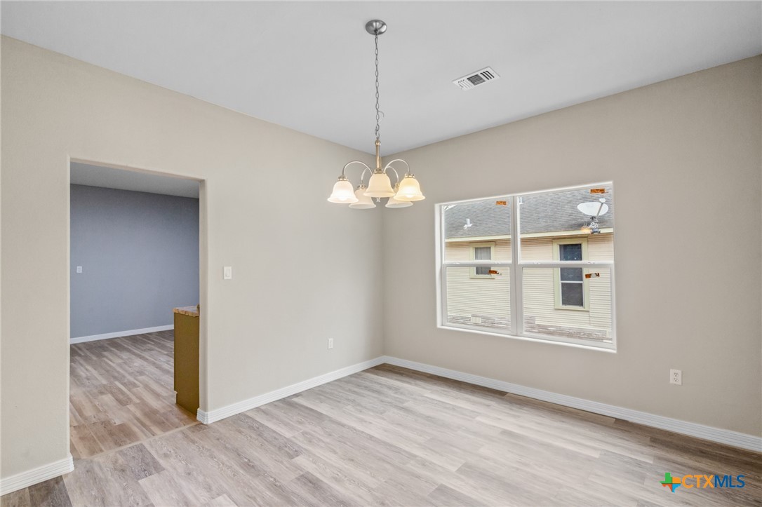 406 Hubbard Street Yoakum, TX 77995 - Photo 8 of 37 a view of a room with wooden floor chandelier and a window