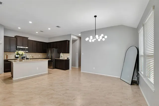 a view of an empty room with a window and a kitchen