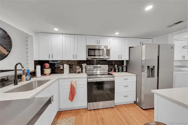 a kitchen with granite countertop a refrigerator stove and sink