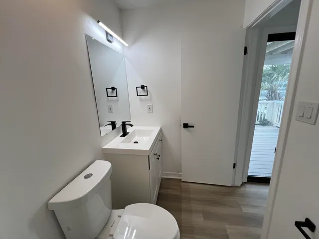 a bathroom with a sink a toilet a mirror and shower
