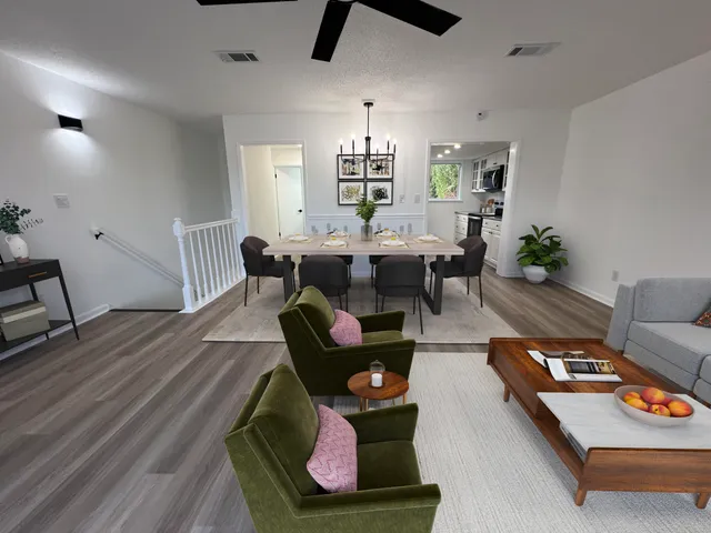 a view of a kitchen with wooden floor electronic appliances and stairs