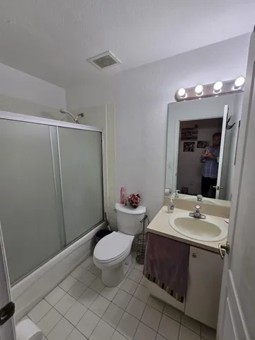 a bathroom with a sink mirror vanity and toilet