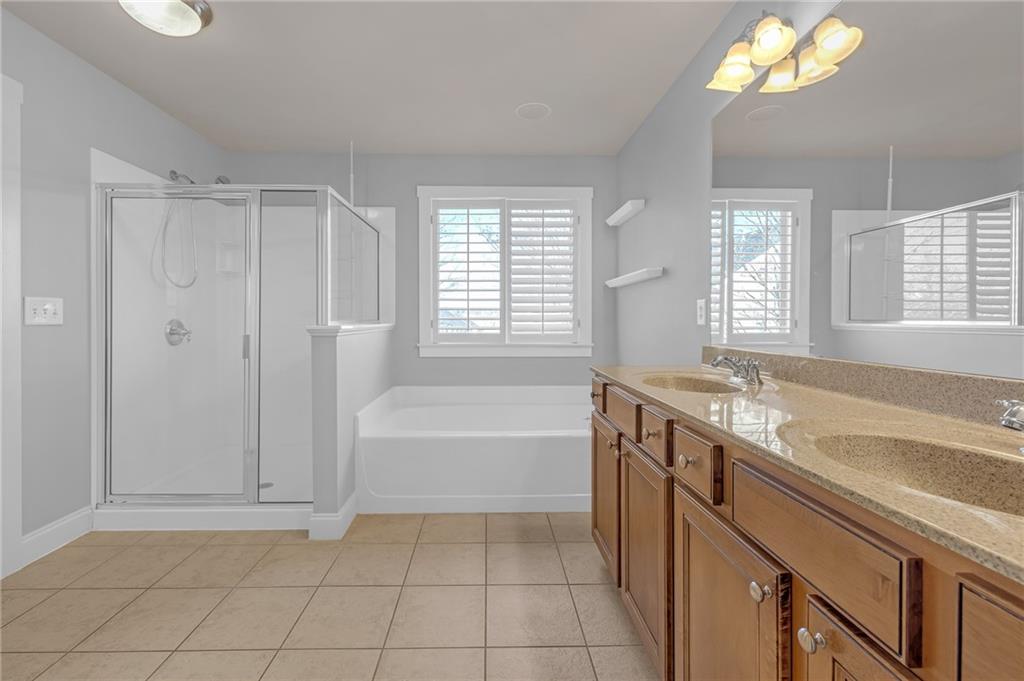 2048 Village Crest Drive Northwest Atlanta, GA 30318 - Photo 17 of 21 a spacious bathroom with a tub sink and mirror