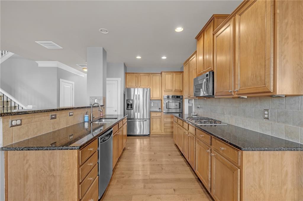2048 Village Crest Drive Northwest Atlanta, GA 30318 - Photo 6 of 21 a kitchen with stainless steel appliances granite countertop a sink a stove and a refrigerator
