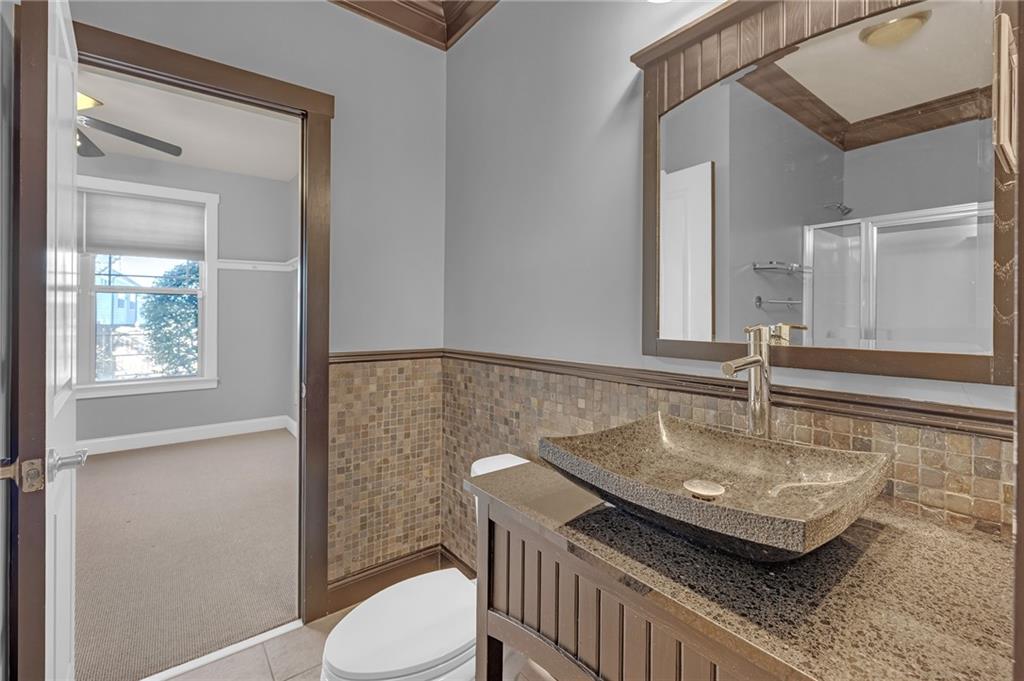 2048 Village Crest Drive Northwest Atlanta, GA 30318 - Photo 8 of 21 a bathroom with a granite countertop sink a toilet and a mirror