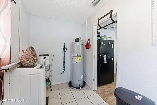 a view of storage and utility room with refrigerator and washer