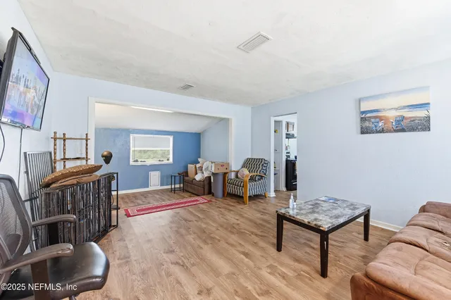 a living room with furniture and a wooden floor