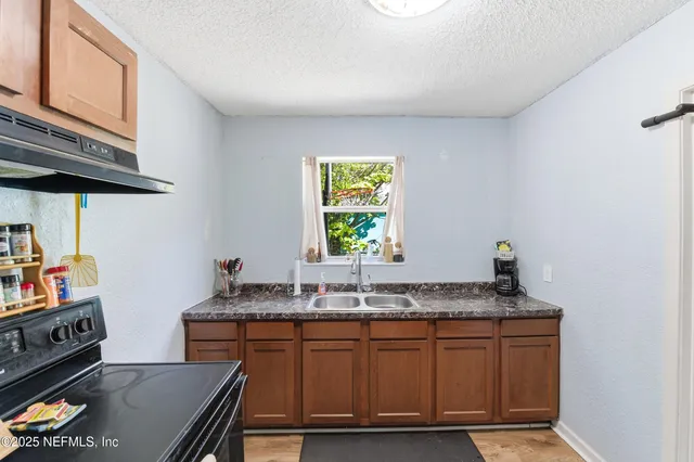 a kitchen with granite countertop a sink cabinets and window