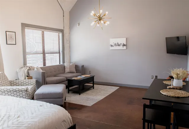 a living room with furniture a chandelier and a window