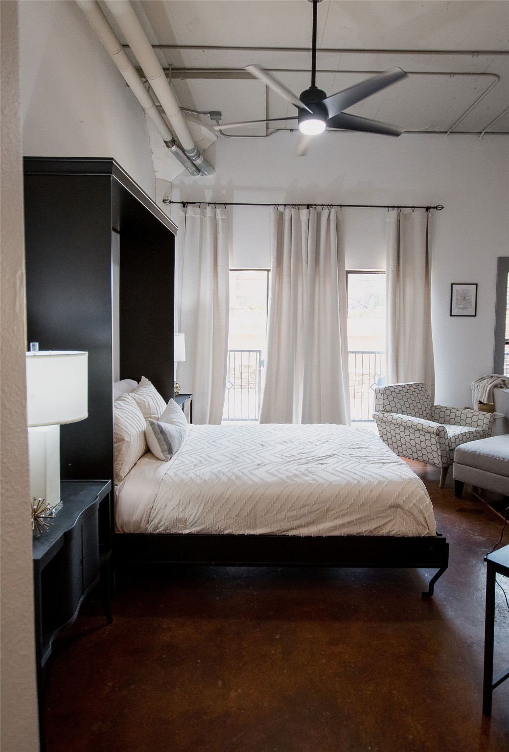 2205 McKinney Street, Unit 309 Houston, TX 77003 - Photo 9 of 14 a bedroom with a bed and a chandelier