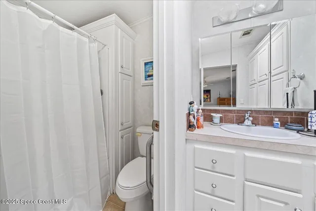 a bathroom with a granite countertop sink toilet and mirror