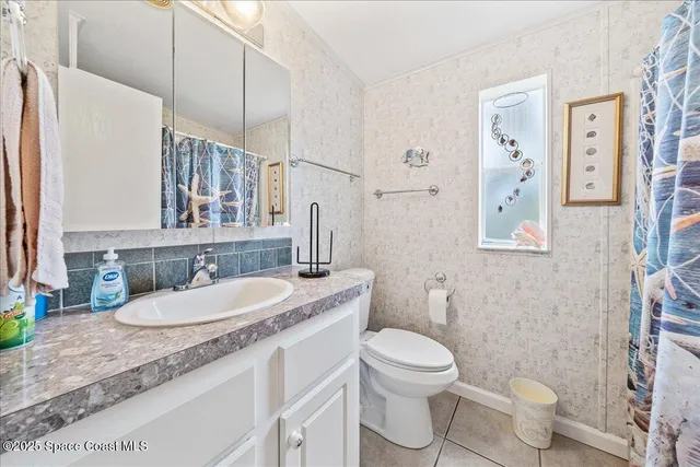 a bathroom with a granite countertop toilet sink and mirror