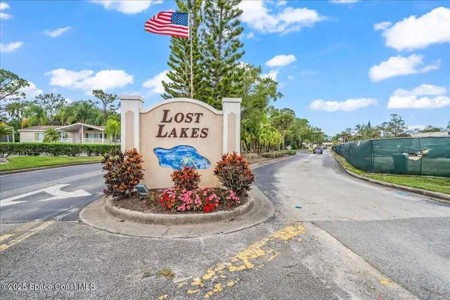 a sign board with a play ground in the back yard