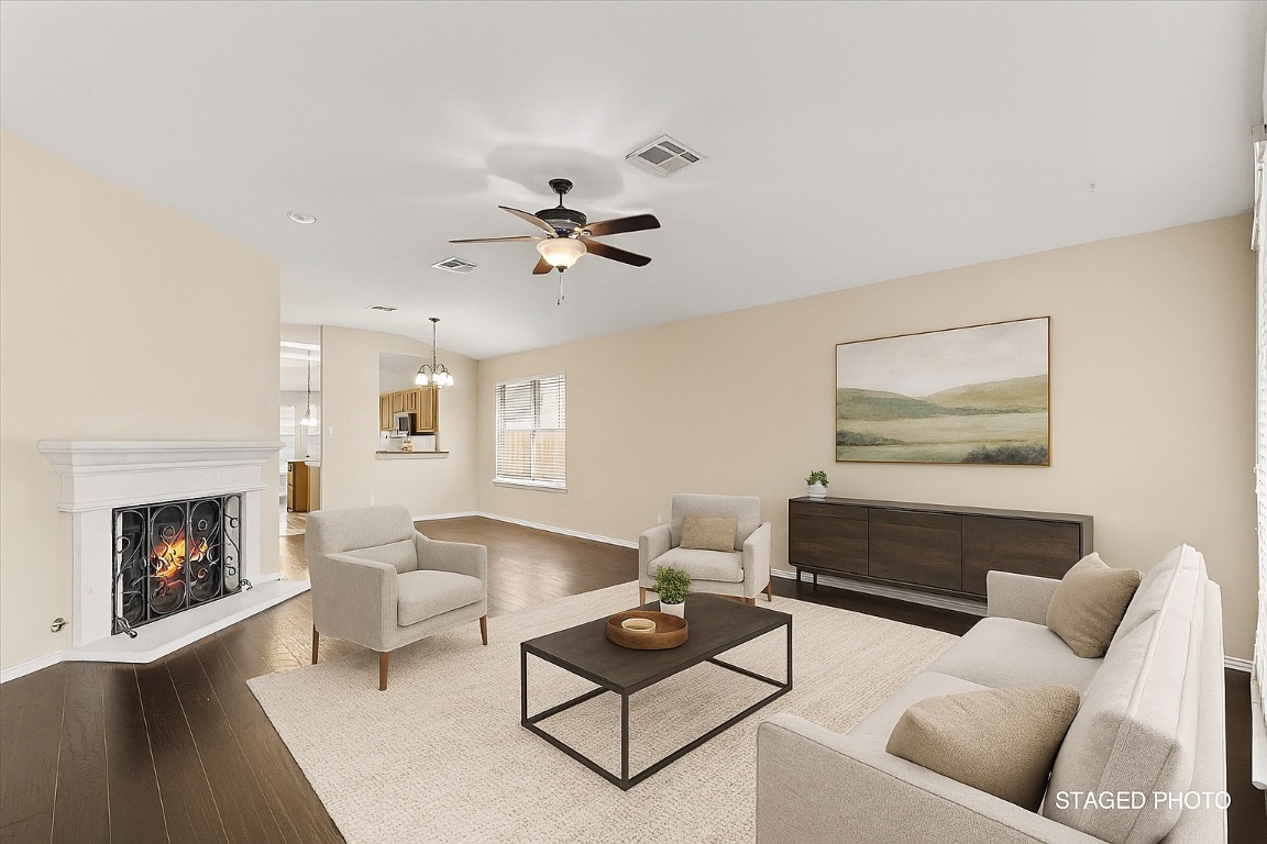 13438 Moscow Trail Austin, TX 78729 - Photo 1 of 40 Virtually Staged Living room featuring a ceiling fan, dark wood finished floors, and a lit fireplace