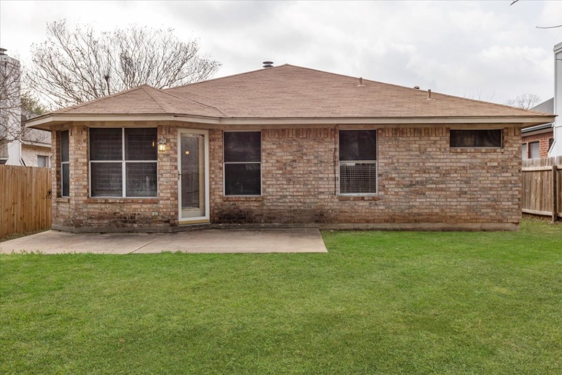 13438 Moscow Trail Austin, TX 78729 - Photo 34 of 40 Back of house featuring a patio area, a shingled roof, a chimney, and brick siding