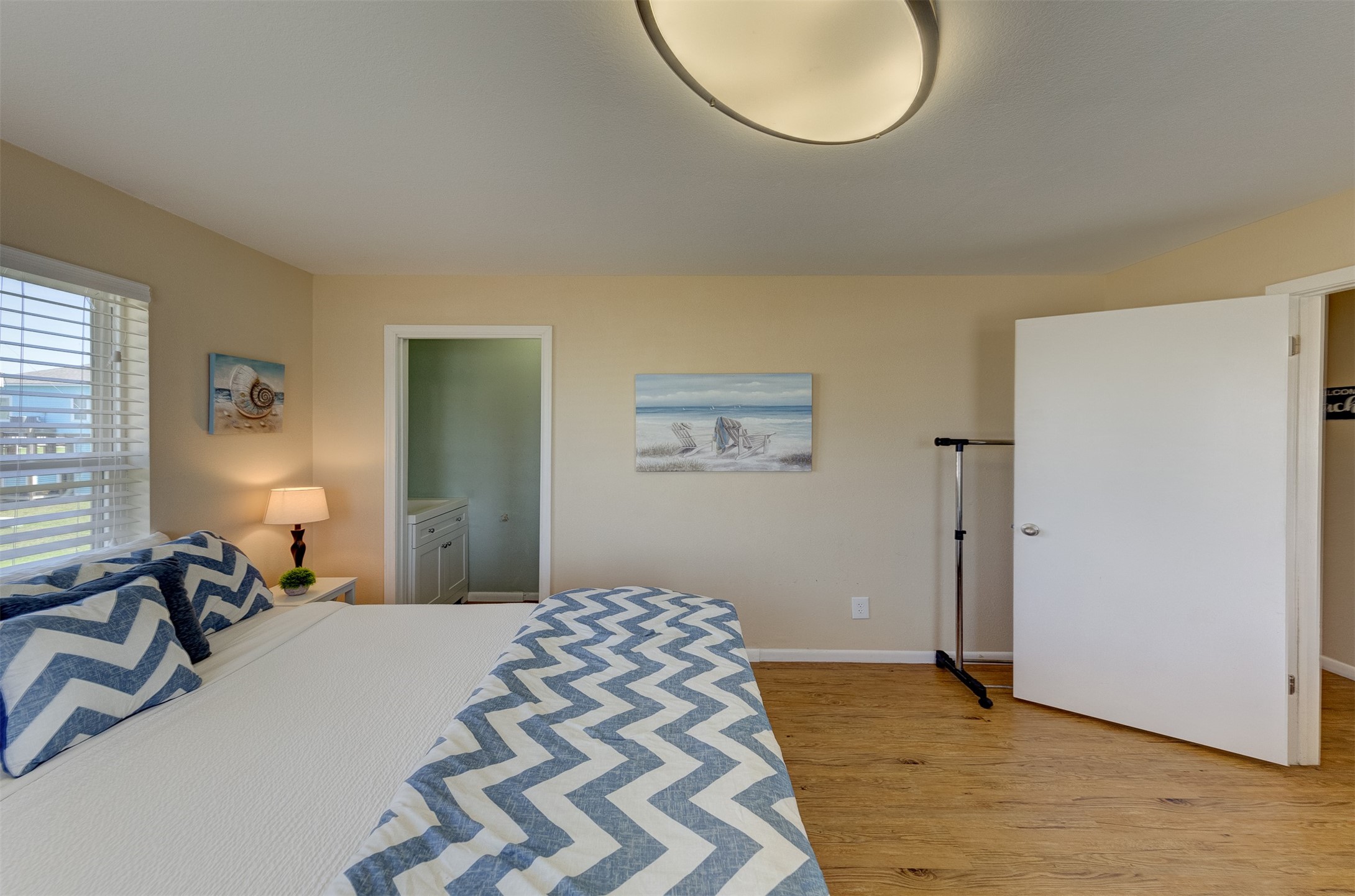 23005 Fresca Street Galveston, TX 77554 - Photo 18 of 37 a bedroom with a bed and a chandelier