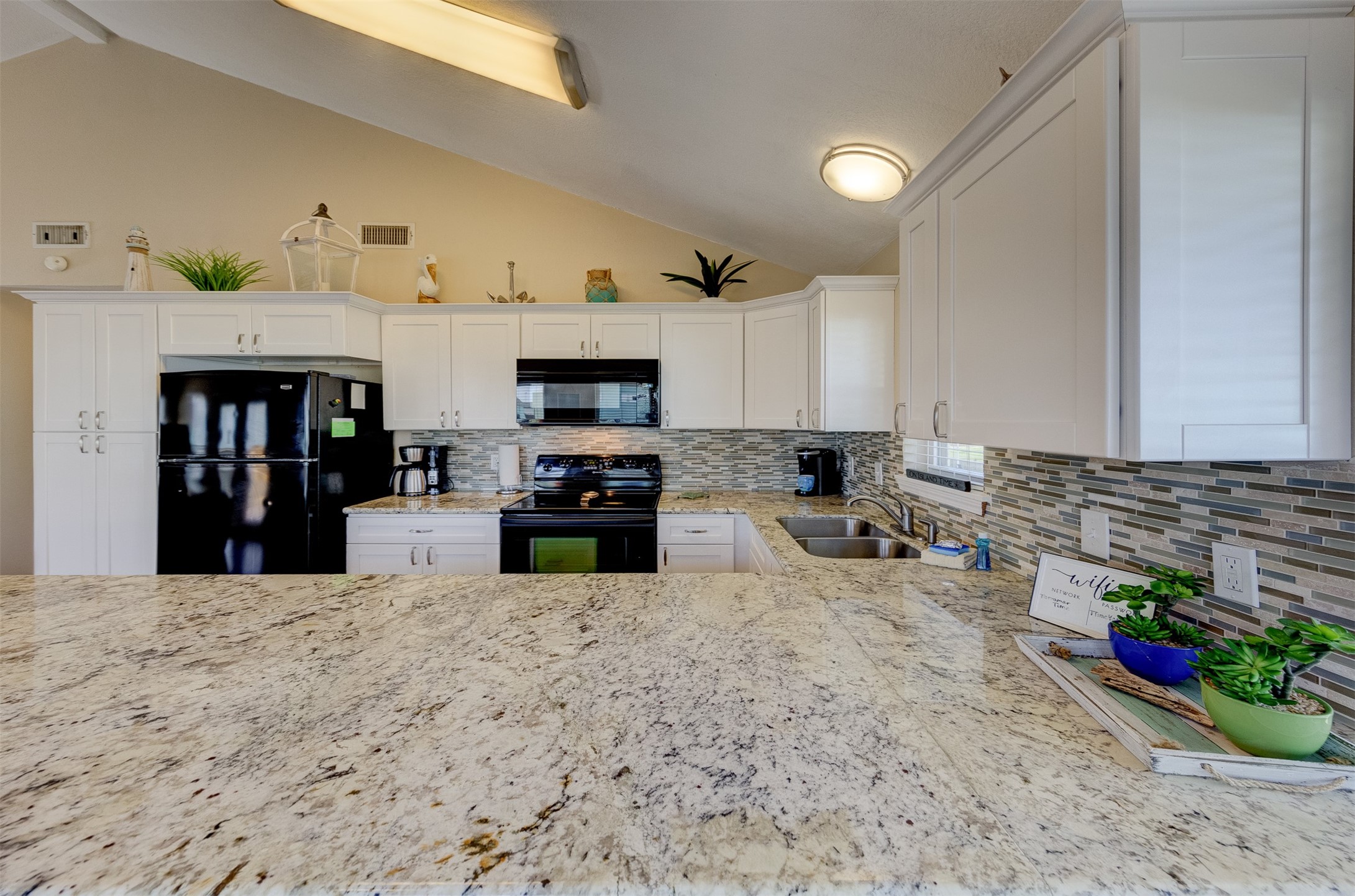 23005 Fresca Street Galveston, TX 77554 - Photo 9 of 37 a kitchen with stainless steel appliances kitchen island sink refrigerator and stove