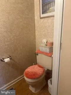 a bathroom with a granite countertop toilet and a sink