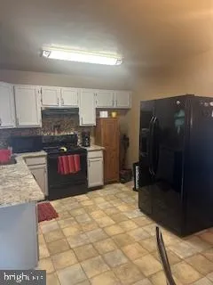 a kitchen with stainless steel appliances granite countertop a refrigerator and a stove