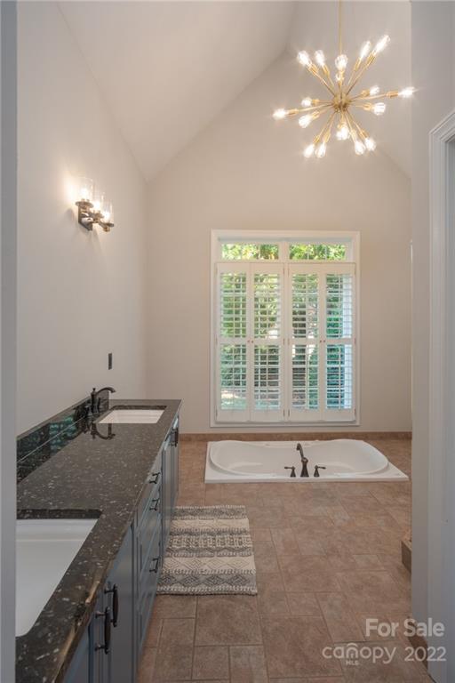 2900 Sliding Rock Trail Fort Mill, SC 29708 - Photo 17 of 41 a spacious bathroom with a granite countertop sink a large mirror and a bathtub